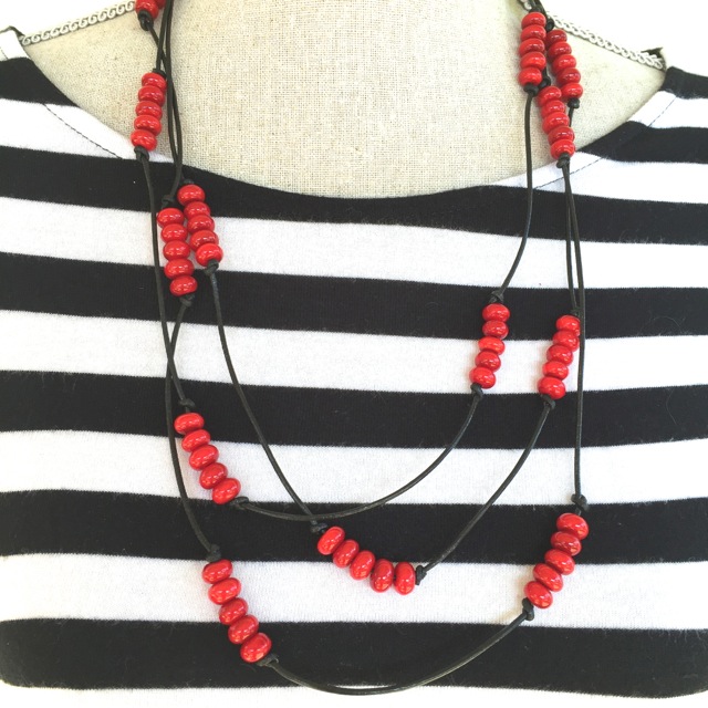 Handmade red glass beads on black leather