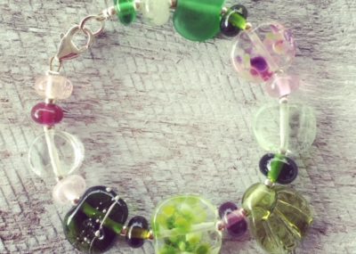 Recycled glass flower bracelet | beads made from assorted wine bottles and other broken glass objects.
